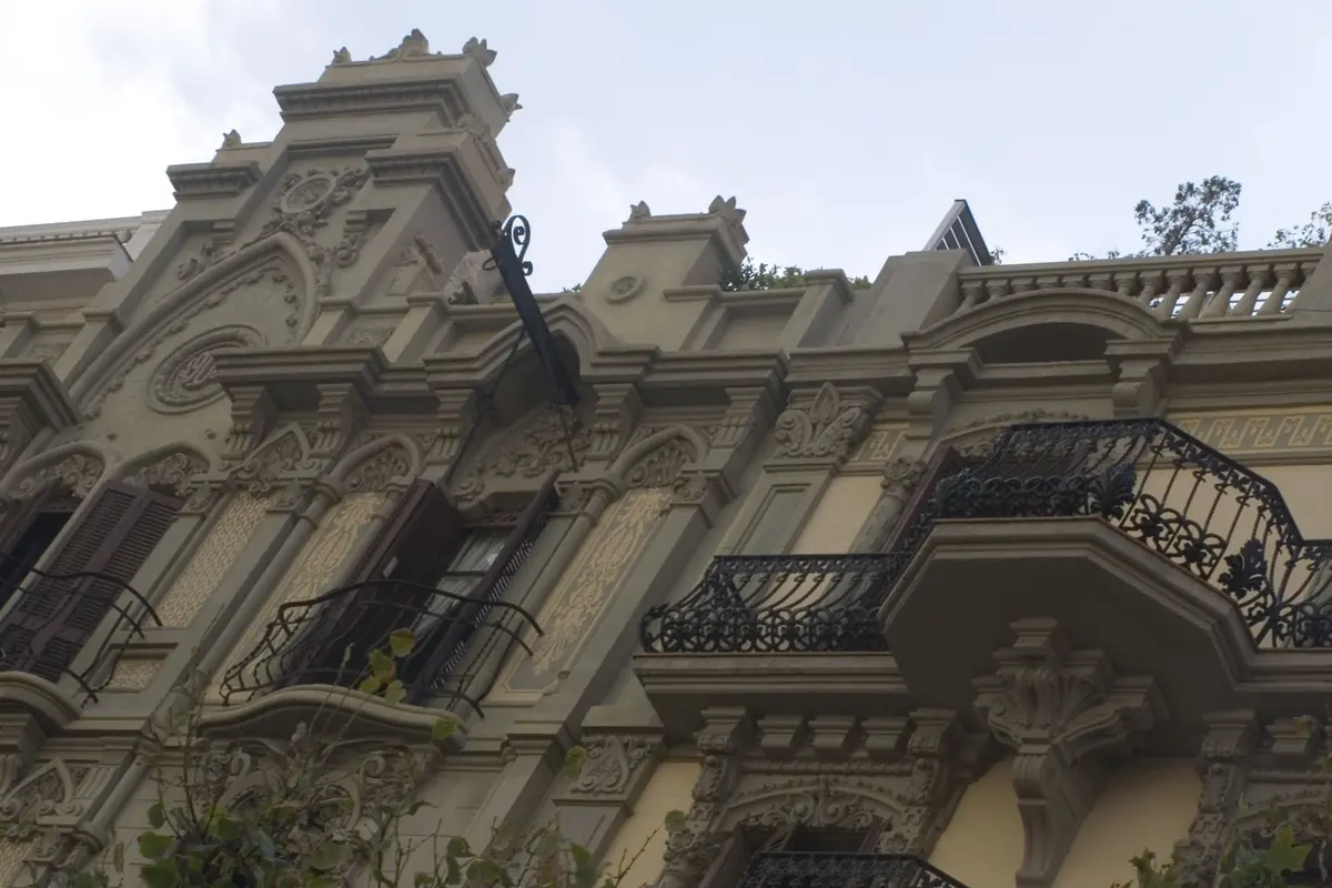 An ornate stone facade with wrought-iron balconies on Rambla de Catalunya in Barcelona.